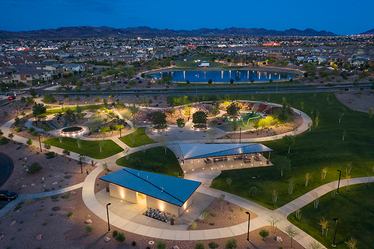 A building with a pool in the middle of a field with a city in the background.