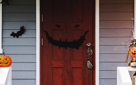A door with a carved pumpkin and a bird on it.