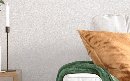 A bed with a pillow and a lamp on the side.