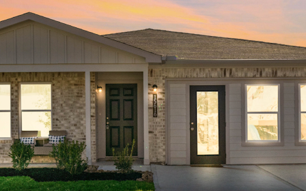 A house with a driveway and trees.