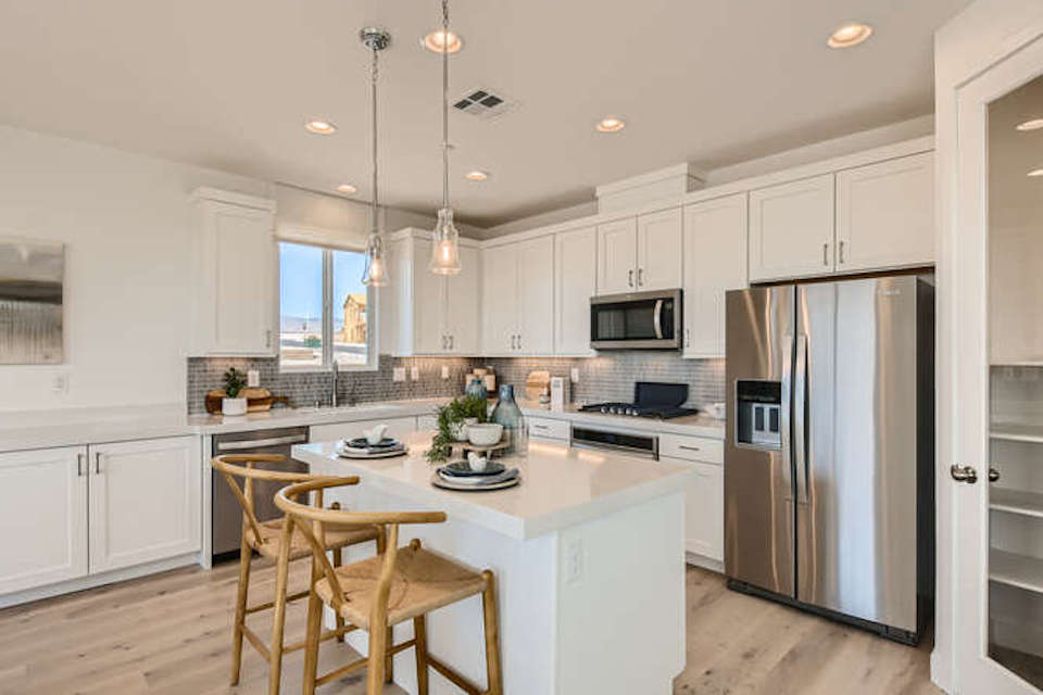 A kitchen with white cabinets.
