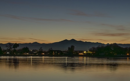 A body of water with trees and mountains in the background.