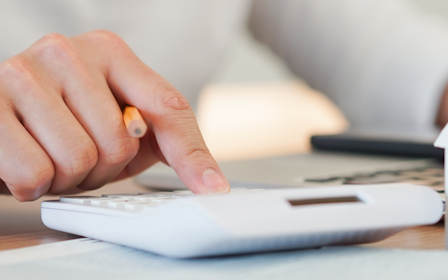 A person's hand on a stack of white cubes.