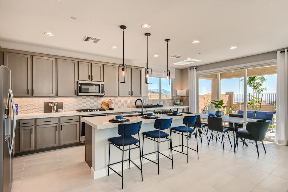 A kitchen with a dining table and chairs.
