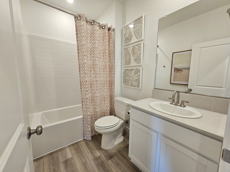 A bathroom with a sink toilet and a shower.