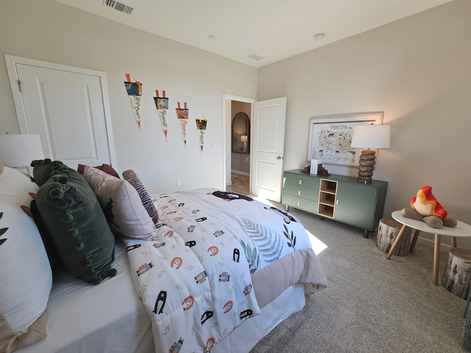 A bedroom with a bed and a table.