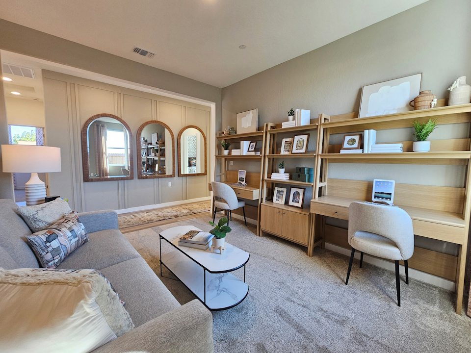 A living room with a desk and a couch.
