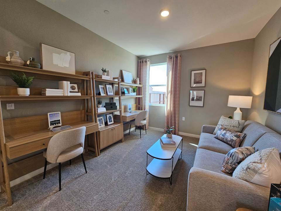 A living room with a desk and a couch.