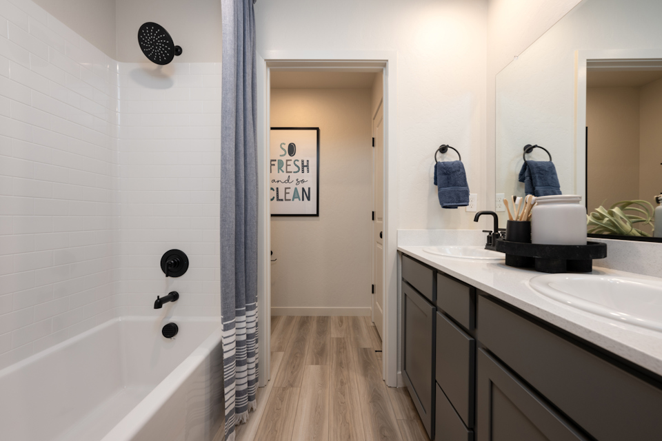 A bathroom with a tub sink and a mirror.
