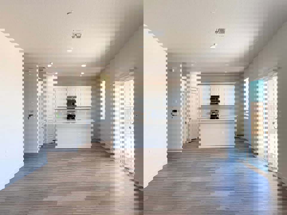 A large empty room with white cabinets.