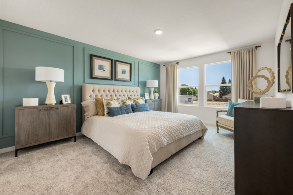 A bedroom with a bed and a chair.