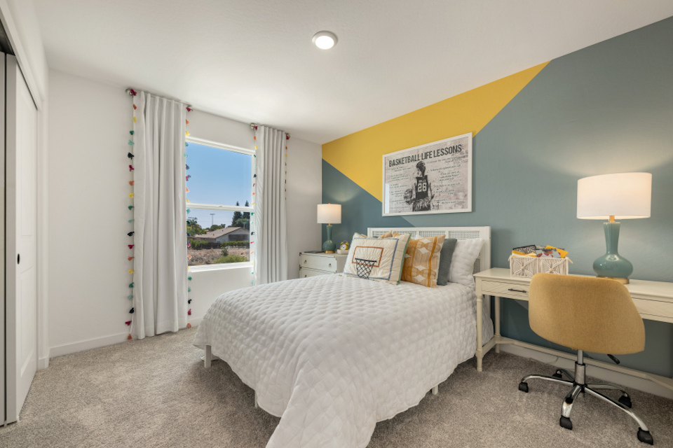 A bedroom with a bed and a desk.