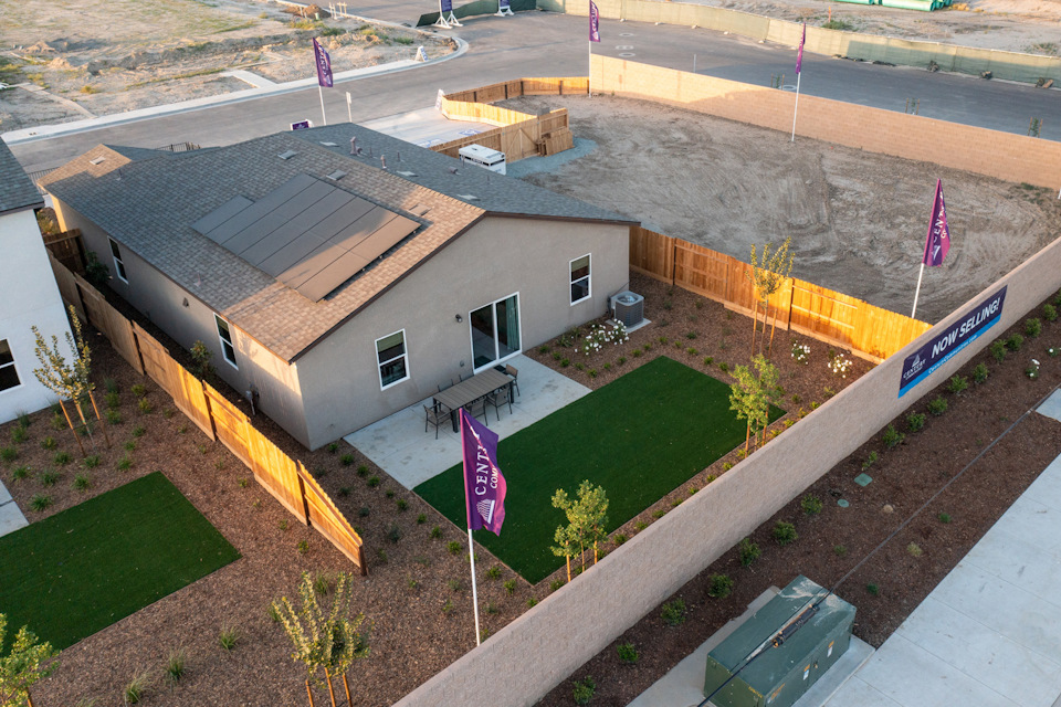 A house with a lawn and a parking lot.