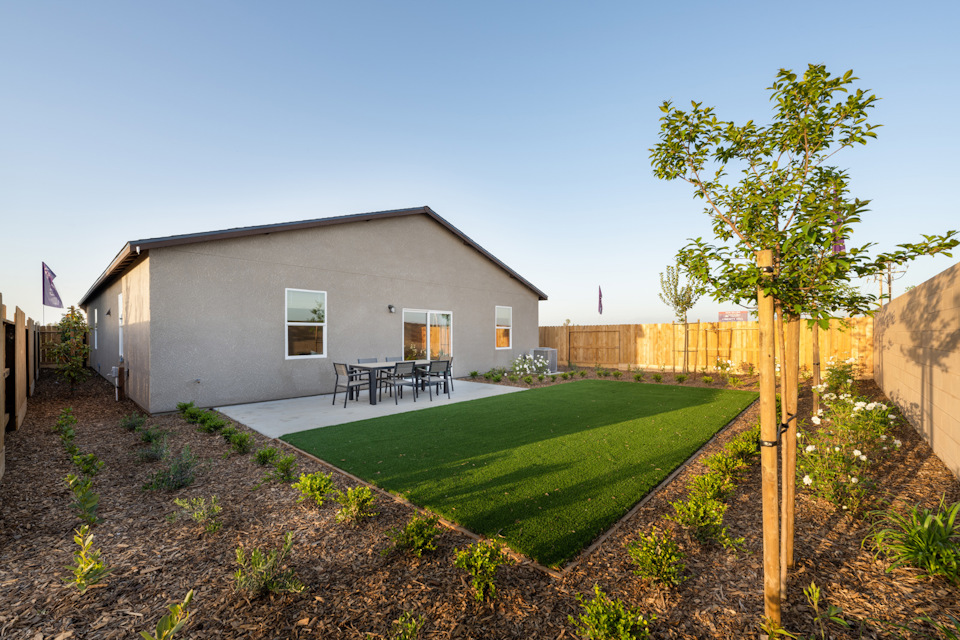 A backyard with a fence and a house.