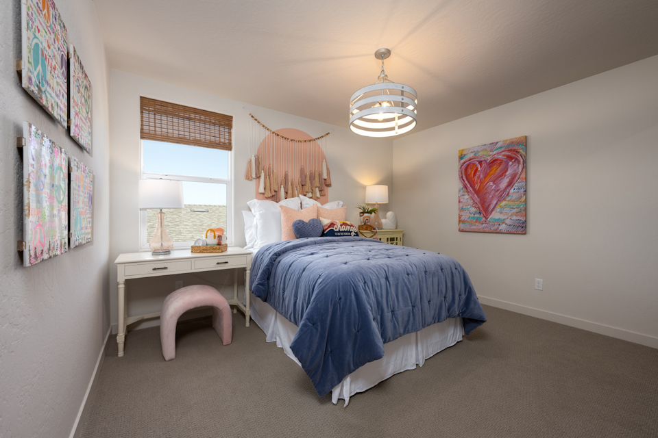 A bedroom with a bed and desk.