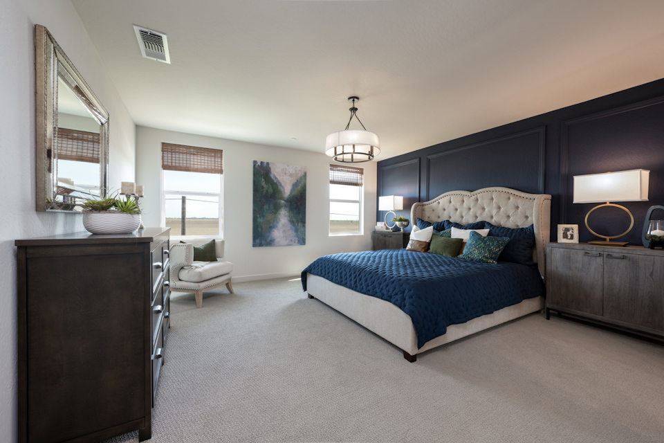 A bedroom with a bed and a chair.