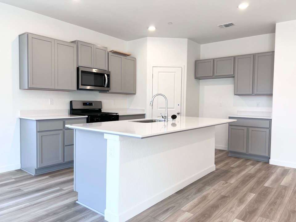A kitchen with white cabinets.