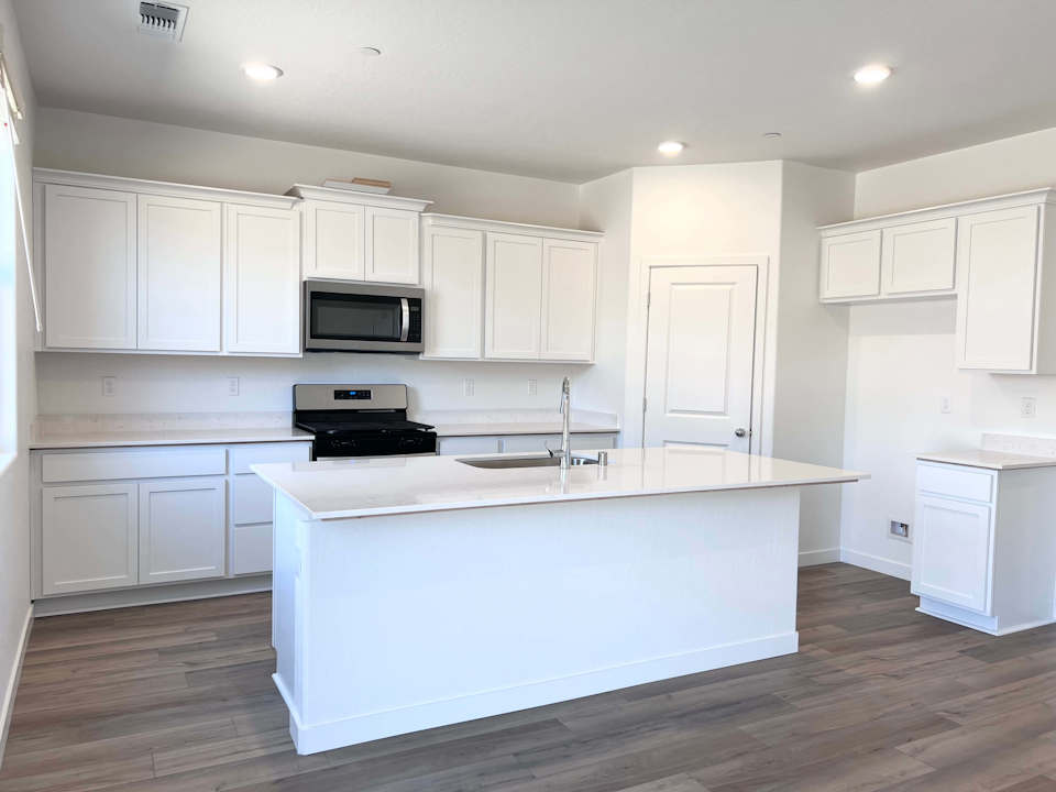 A kitchen with white cabinets.