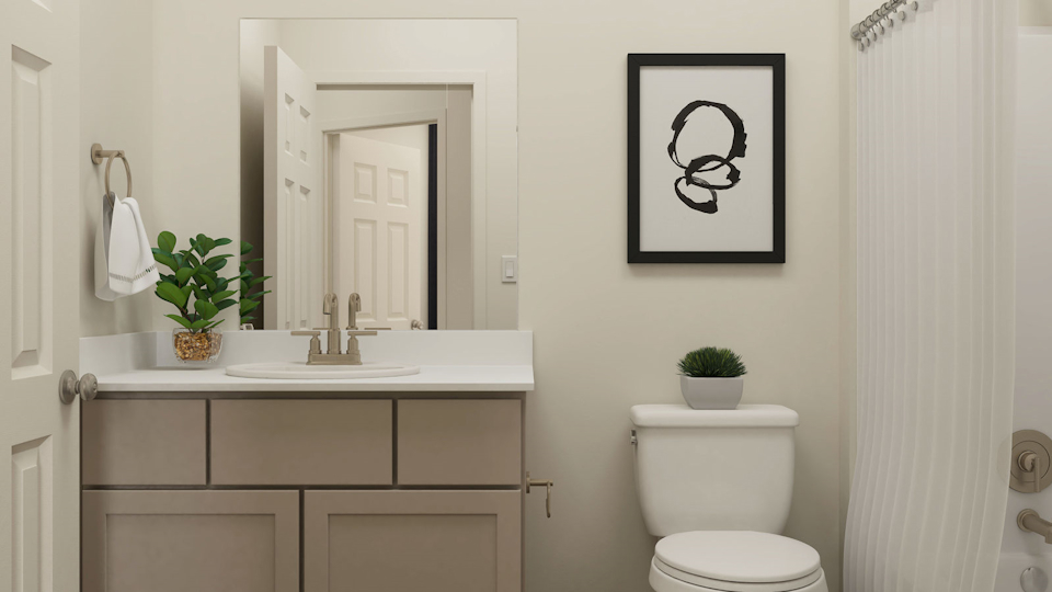 A bathroom with a sink toilet and a plant.