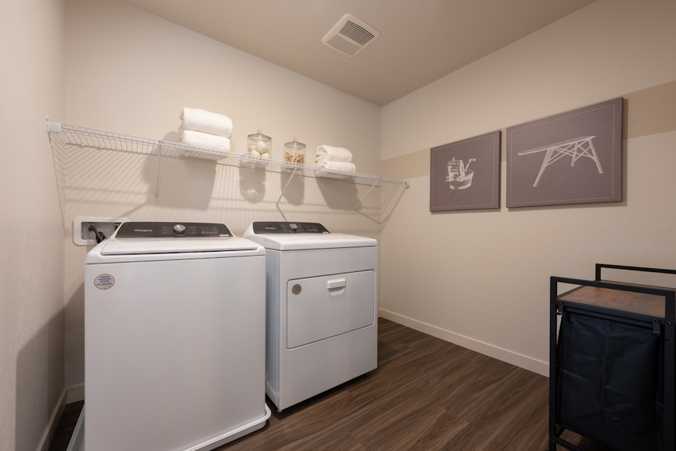 A kitchen with a white stove and white cabinets.