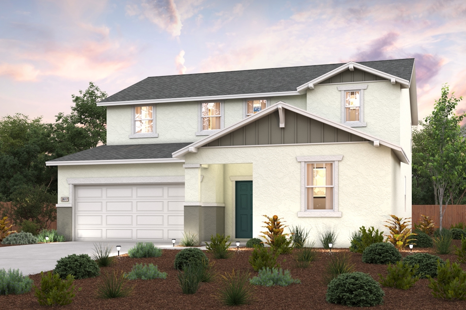 A house with a garage and bushes in front of it.