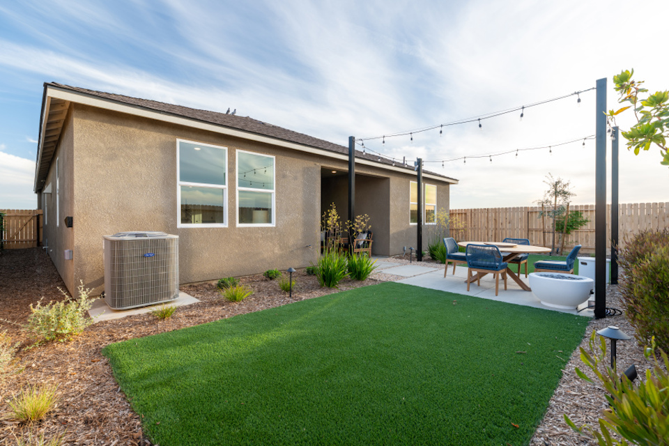 A backyard with a pool and chairs.