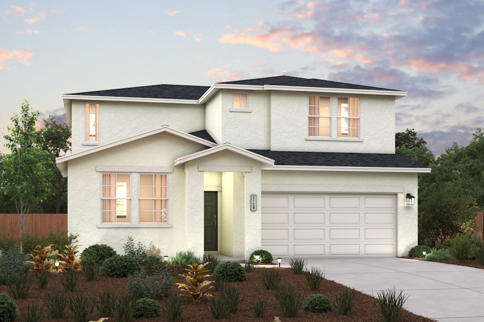 A house with a garage and bushes in front of it.