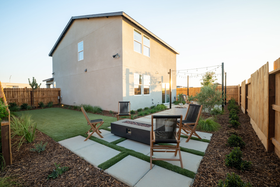 A backyard with a table and chairs.