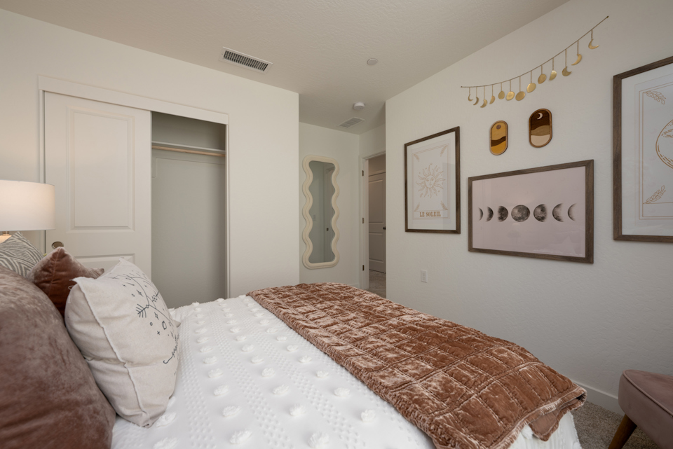 A bedroom with a bed and a lamp.