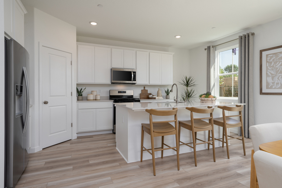 A kitchen with white cabinets.