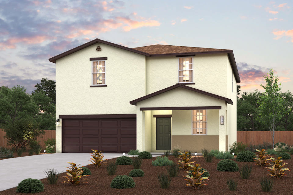 A house with a garage and bushes in front of it.