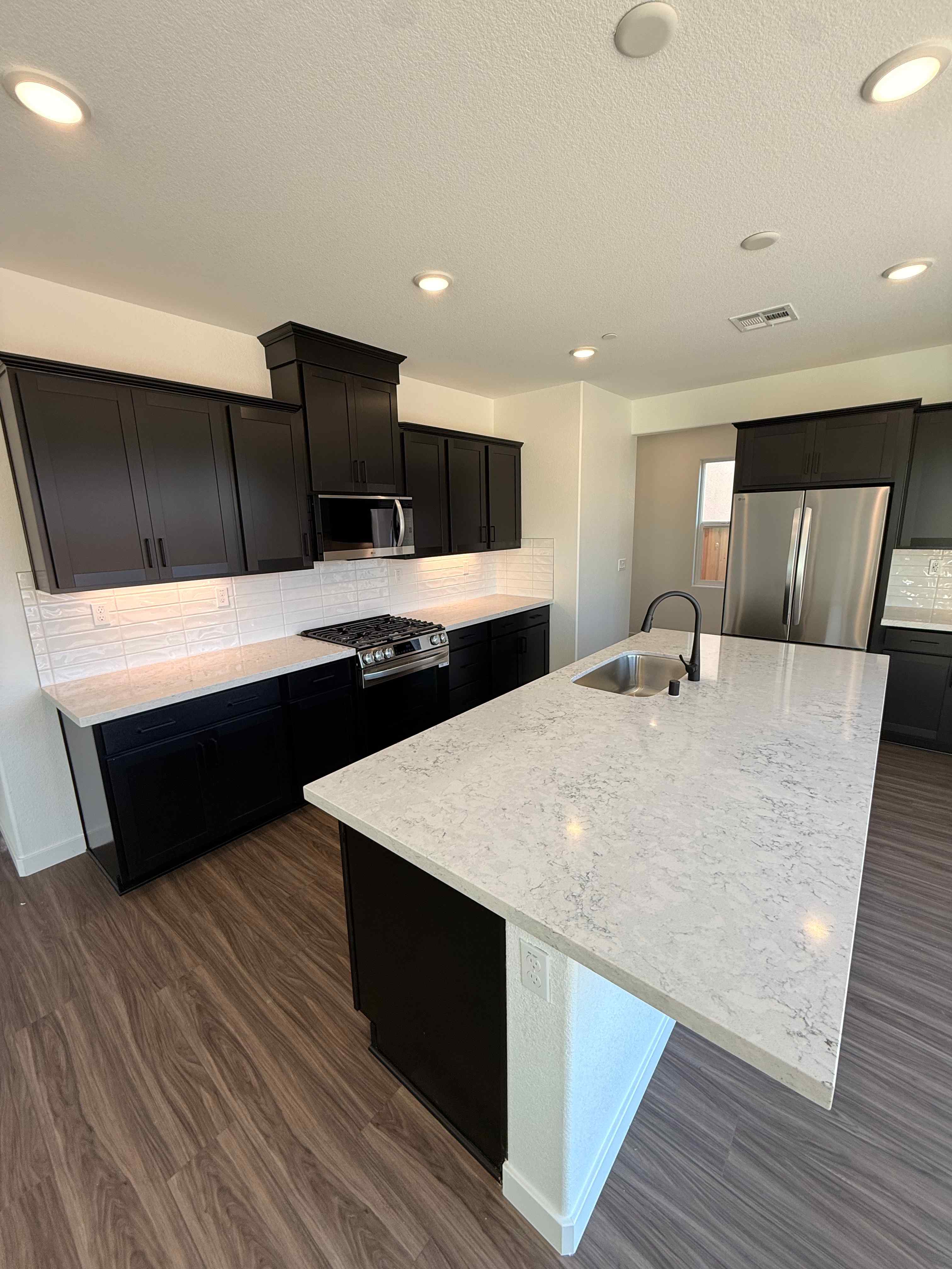 A kitchen with black cabinets.