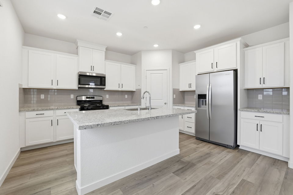 A kitchen with white cabinets.