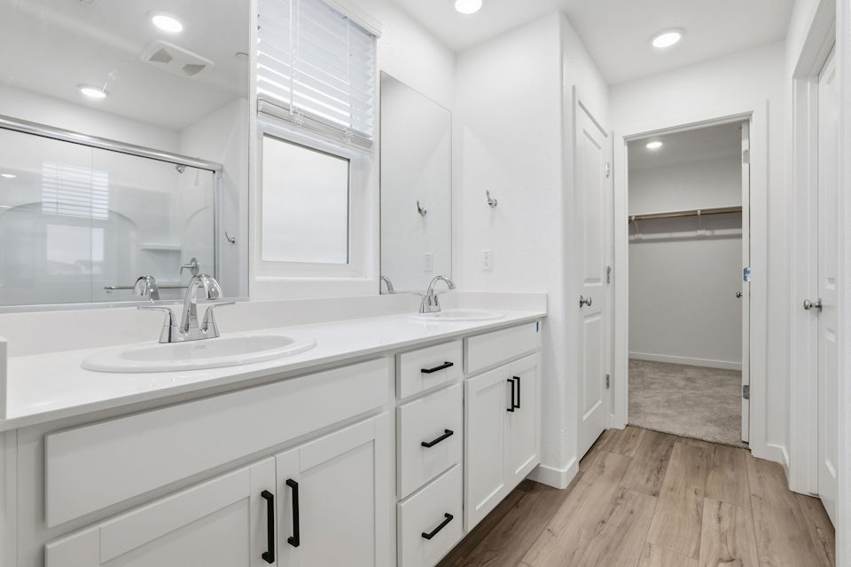 A bathroom with white cabinets.