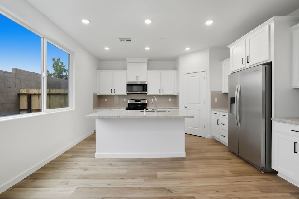 A kitchen with white cabinets.