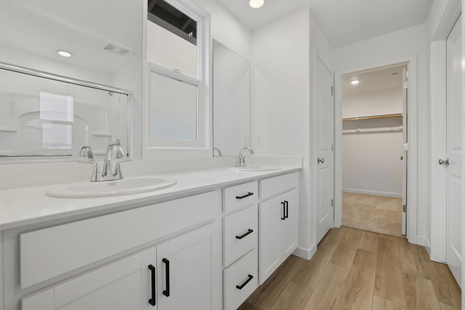 A bathroom with white cabinets.