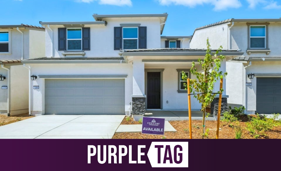 A white house with a sign in front of it.