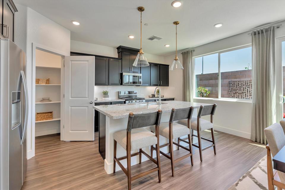 A kitchen with a dining table and chairs.