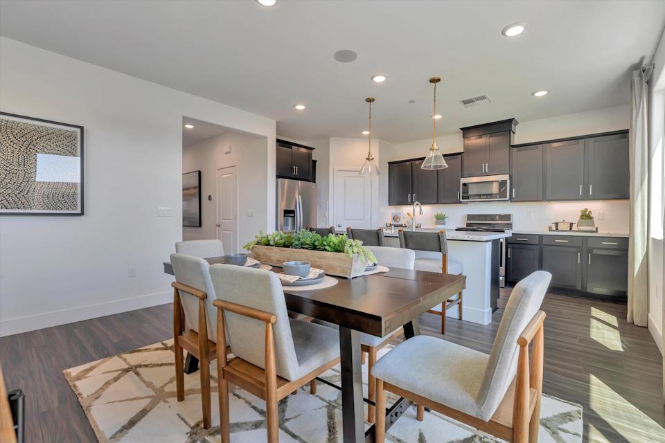 A kitchen with a dining table and chairs.