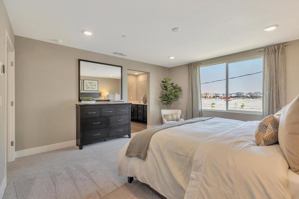 A bedroom with a large window.