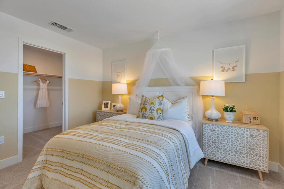 A bedroom with a bed and lamps.