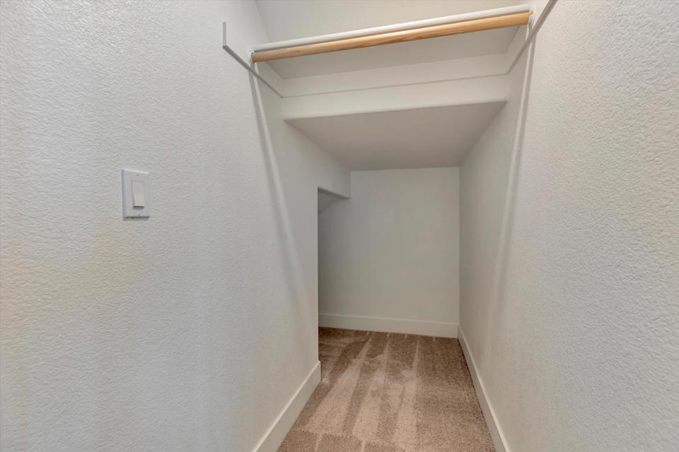A white hallway with a light on the ceiling.