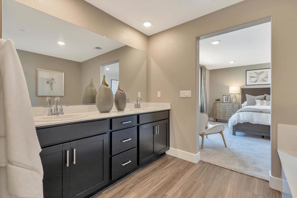 A bathroom with a bed and a mirror.