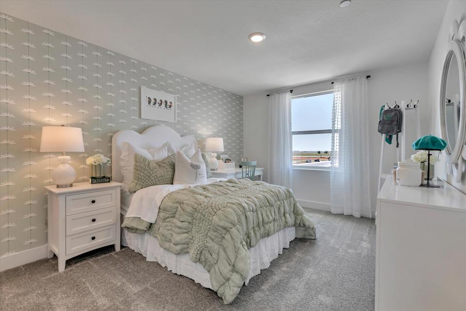 A bedroom with a bed and lamps.