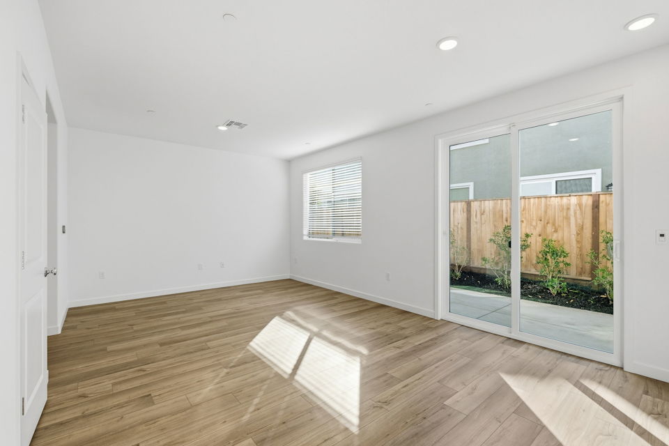 A room with a wood floor and a wood floor with a white door.