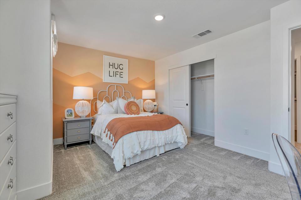 A bedroom with a bed and lamps.