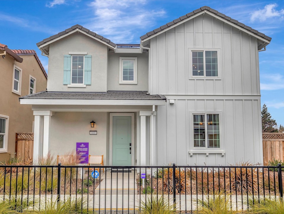 A white house with a black fence.