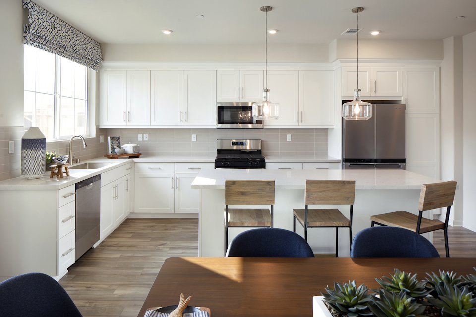 A kitchen with white cabinets.