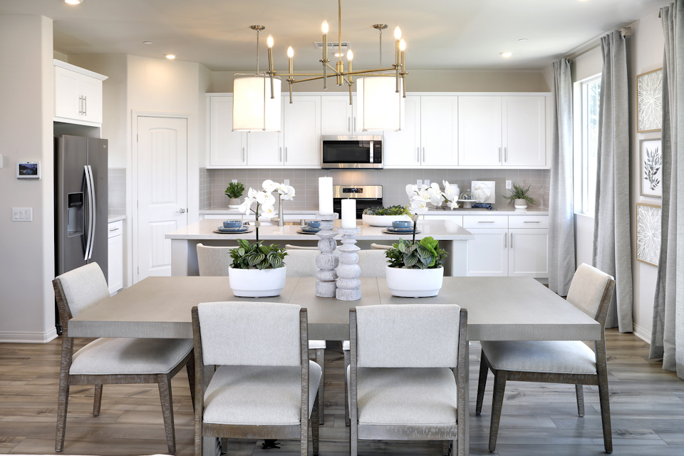 A kitchen with a dining table and chairs.