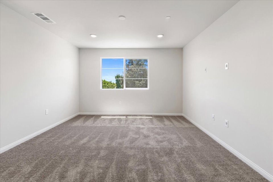 A room with a window and a rug.
